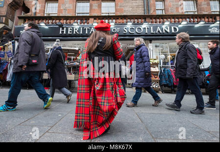 Frau mit Tartan verteilen Flyer für Touristen bei der Tourist Geschenk Shop auf der Royal Mile in Edinburgh, Schottland, Vereinigtes Königreich Stockfoto