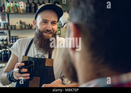 Dedizierte hairstylist Kaffee trinken, mit seinem Kunden und Freund Stockfoto