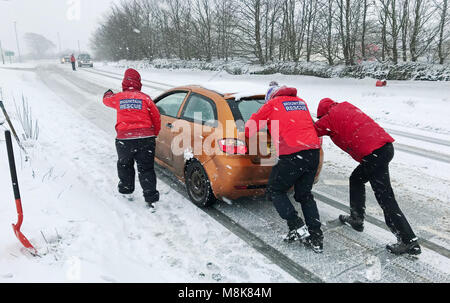 Mitglieder des Nordens Dartmoor Suche und Rettung Team Team ein Kraftfahrer auf einer Straße unterstützen Sie die A 30 in der Nähe von Okehampton in Devon als schweren Schnee Verkehrschaos zu Teilen der South West gebracht. Stockfoto