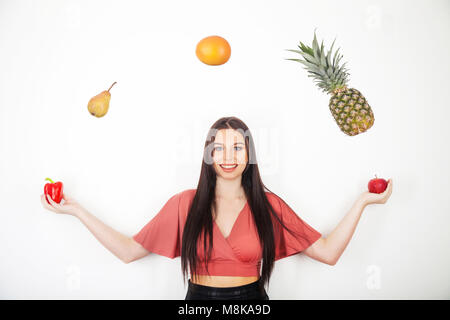 Ein hübsches junges Mädchen jonglieren ihre fünf am Tag von Obst und Gemüse Stockfoto