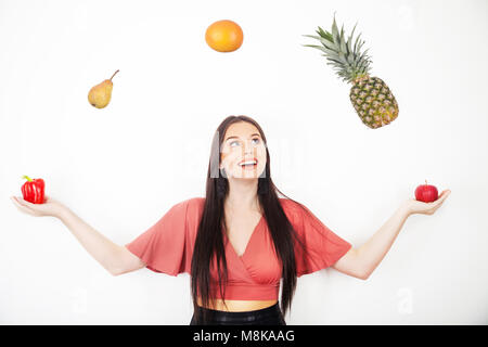 Ein hübsches junges Mädchen jonglieren ihre fünf am Tag von Obst und Gemüse Stockfoto