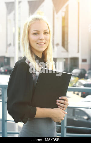 Young Business Frau mit Zwischenablage steht auf dem Balkon des Amtes Stockfoto