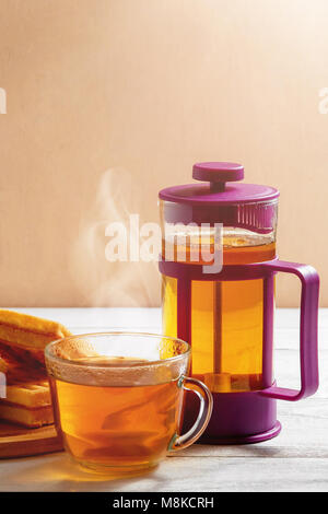 Selbstgemachte Waffeln mit Marmelade auf alten Holztisch. Wafer mit Tasse Kaffee und Teekanne. Stockfoto