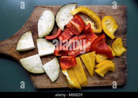 In Scheiben geschnittene Aubergine und Paprika auf Schneidebrett Stockfoto