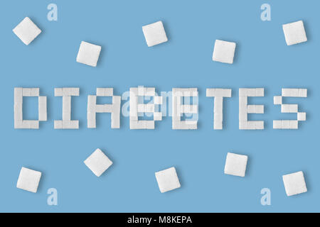 Wort Diabetes mit würfelzucker auf blauem Hintergrund geschrieben Stockfoto