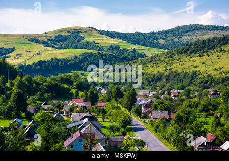 Straße durch das Dorf in den Karpaten. Blick aus der Vogelperspektive auf schöne Landschaft im Sommer Stockfoto
