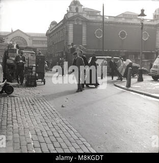 1950er Jahre, historische Bild aus dieser Zeit zeigen, am frühen Morgen in der Straße außerhalb Londons berühmten Covent Garden Markt für Obst und Gemüse. Stockfoto