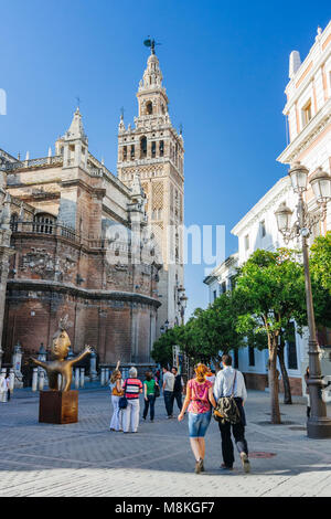 Sevilla, Andalusien, Spanien: Touristen zu Fuß in Richtung der Gotischen Kathedrale und Giralda Glockenturm an der Plaza del Triunfo Square. Stockfoto