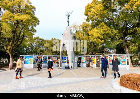 Japan, Hiroshima. Menschen und Touristen, die die Kinder Peace Memorial Sadako Sasaki zu gedenken. Trübes Wetter. Stockfoto