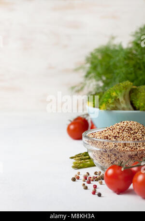 Gesunde Ernährung Essen. Quinoa in eine Glasschüssel, Cherry Tomaten, Spargel, Brokkoli auf einen hellen Hintergrund konkrete Stockfoto