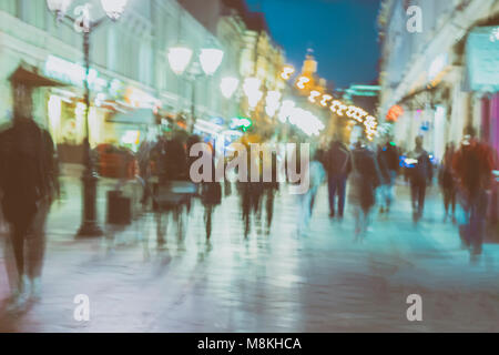 Abstraktes Bild der unkenntlich Silhouetten von Menschen zu Fuß in der Stadt Straße in Abend, Nachtleben. Städtische moderne Hintergrund, motion Effekt Stockfoto