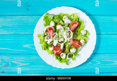Caprese Salat. Cherry-Tomaten, Spinat und Mozzarella in Metallschale mit Pesto Dressing rustikalen Holzmöbeln Hintergrund, Ansicht von oben, horizontal Stockfoto