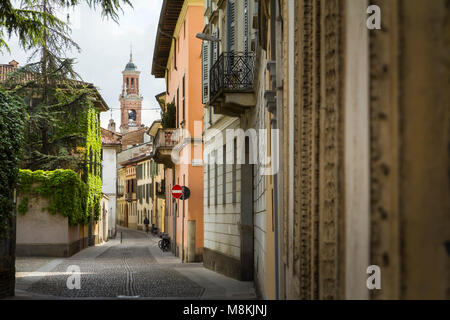 Einer ruhigen Seitenstraße im Zentrum von Crema, Italien, mit einem Turm auf der Achse. Stockfoto