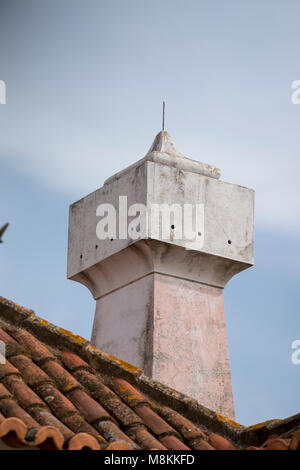 Typische Schornsteine auf roten Ziegeldächern in portugiesischer Architektur. Stockfoto