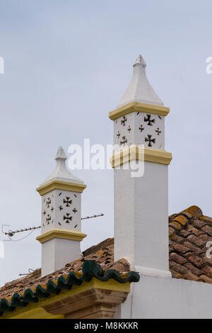 Typische Schornsteine auf braun Ziegeldächern in portugiesischer Architektur. Stockfoto