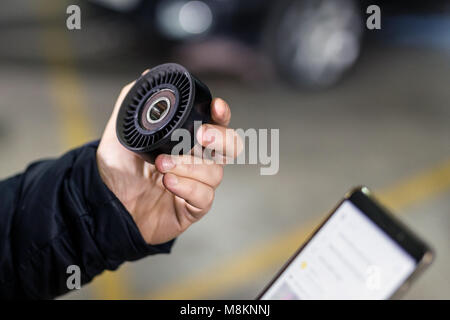 Mechaniker hand Auto Ersatzteil und Bestellung Neues über Smartphones. Fahrzeug Wartung und Service Station. Browsing für den günstigsten Preis im Internet. Suche Rabatt und Vertrieb Stockfoto