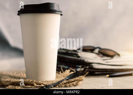 Tasse Kaffee und Zeitung auf Holz. Stockfoto