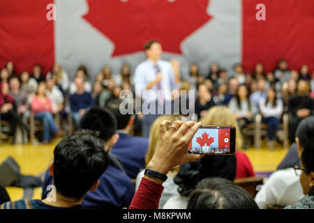 Hand von einer Frau mit einem Handy ein Bild von Justin Trudeau, Premierminister von Kanada, einem Town hall Meeting in London, Ontario, Kanada. Stockfoto