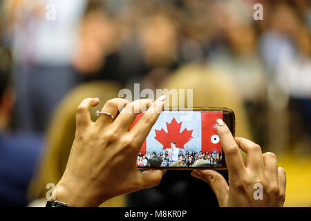 Hände von einer Frau mit einem Handy ein Bild von Justin Trudeau, Premierminister von Kanada, einem Town hall Meeting in London, Ontario, Kanada. Stockfoto