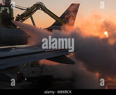 Austin, Texas - 3. Januar 2018: Fluglinie Arbeiter Entfrostung ein Jet Blue Commercial Airplane, bevor Sie in den frühen Morgen. Blick aus dem Ai Stockfoto