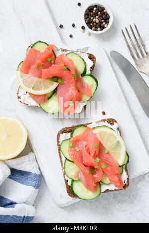 Geräucherter Lachs, Quark und Gurken toast Sandwiches auf Weiß. Ansicht von oben Stockfoto