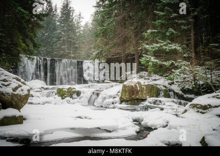 Wild Wasserfall, bekannt als Dziki Wodospad, in der wunderschönen Landschaft des Riesengebirges in Karpacz, Polen, fotografiert im Winter Stockfoto