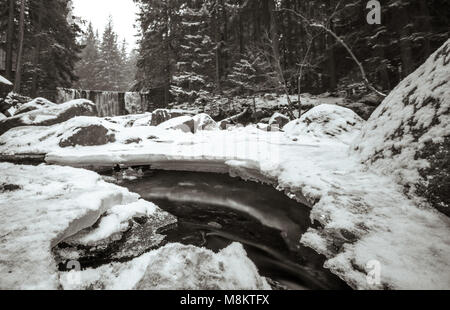 Wild Wasserfall, bekannt als Dziki Wodospad, in der wunderschönen Landschaft des Riesengebirges in Karpacz, Polen, fotografiert im Winter Stockfoto