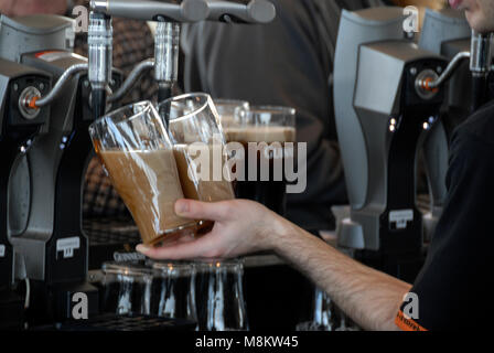 Guinness wird in der Gravity Bar in ein Glas gegossen, wo sich die Besucher im Guinness Storehouse in der Brauerei in Dublin in S entspannen können Stockfoto