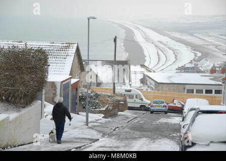 Portland, Dorset. März 2018 18 - ein Mann nimmt seinen Hund für einen Spaziergang im Fortuneswell, Isle of Portland, ein Ort, der kaum Schnee Credit sieht: stuart Hartmut Ost/Alamy leben Nachrichten Stockfoto