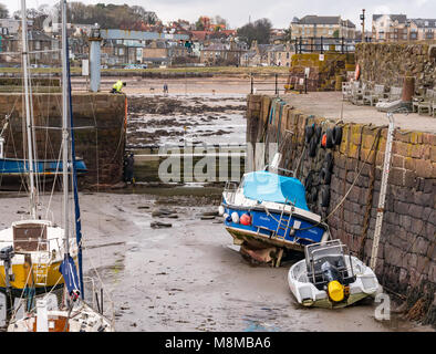 North Berwick, East Lothian, Schottland, Großbritannien, 19. März 2018. Sehr kalter windiger Morgen mit Booten, die bei Ebbe im Hafen gestrandet sind, als Arbeiter das Hafentor reparieren Stockfoto