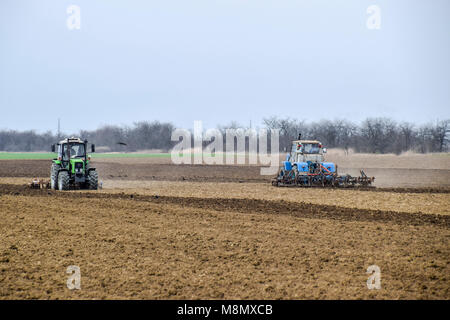 Üppig und lockern den Boden auf dem Feld vor der Aussaat. Der Traktor pflügt ein Feld mit einem Pflug Stockfoto