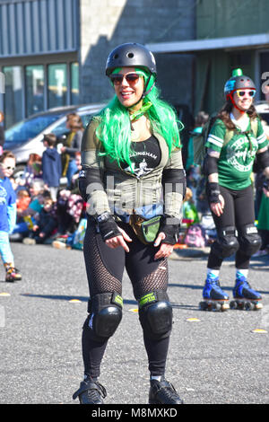 Frau mit Rollschuhen und einen Helm in der Bellingham Washington St. Patrick's Day Parade. Sie hat gepolsterte Knie, Ellenbogen und Handgelenke. Stockfoto