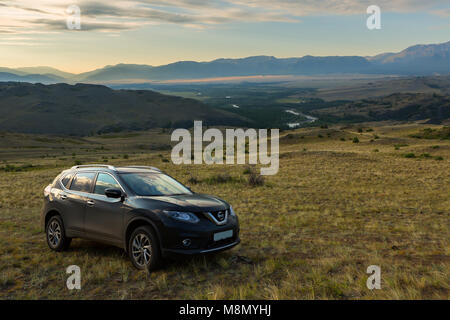 Crossover Nissan X-Trail auf einem Hang in Kurai Steppe vor dem Hintergrund des Nordens Chuy ridge in der Morgendämmerung. Stockfoto