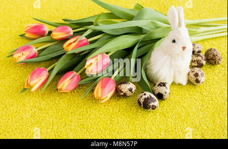 Blumenstrauß aus rosa und gelbe Tulpen mit Osterhasen und Ostereier. Stockfoto