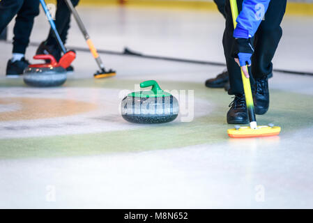 Team Mitglieder spielen in Curling an der Meisterschaft. Stockfoto