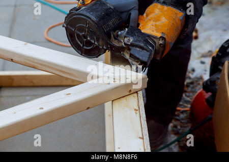 Der Arbeitnehmer macht Ausbauarbeiten der Wände mit einem weißen Holzplatte mit Laser Line Level. Gebäude wärmedämmenden eco-Rahmen aus Holz haus mit Holz Stockfoto