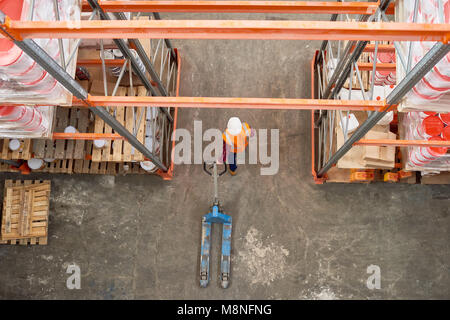 Ansicht von oben Hintergrundbild von hohen Regal Zeilen in moderne Lagerhalle mit Arbeiter tragen, hardhat ziehen Warenkorb leeren Raum in Gang, kopieren Stockfoto