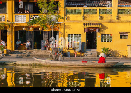 Vietnam Tourismus, Blick bei Sonnenuntergang auf Touristen, die sich in einer Café-Bar am Wasser neben dem Fluss Thu Bon in der Altstadt von Hoi an, Vietnam, entspannen. Stockfoto