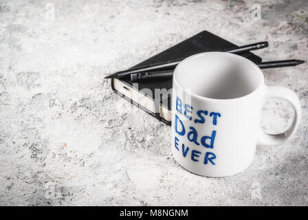 Vatertag Konzept, Hintergrund für Glückwunsch Karten mit einer Tasse mit der Aufschrift beste Vater jemals, Business Notebook und Bleistifte. Kopieren Sie Platz Stockfoto