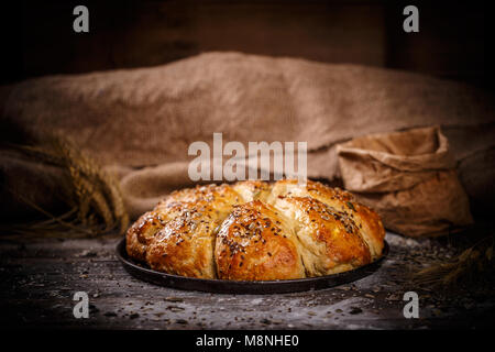 Frisches Frühstück Dreieck Brötchen mit Samen auf rustikalen Hintergrund Stockfoto