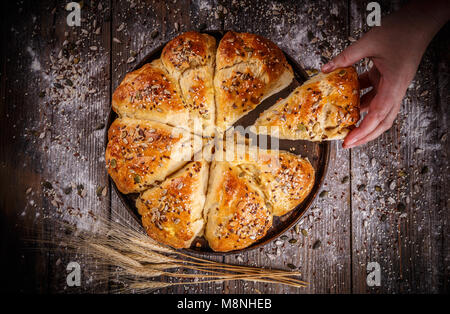 Frisches Frühstück Dreieck Brötchen mit Samen auf Holz- Hintergrund Stockfoto