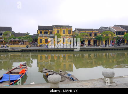 Hoi An, Vietnam - MÄRZ 17, 2018: die große Gruppe der jungen Mädchen in der Vietnamesischen traditionellen Kleid in Hoi An Altstadt mit Blick auf die typische gelbe Häuser Stockfoto