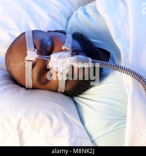 Schlafenden Mann mit Ventilator Schlafapnoe zu behandeln. Stockfoto