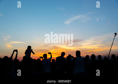 Masse der Leute, die Bilder von den Sonnenuntergang mit Handys und selfie Stick in einer Sommernacht in Florenz, Italien Stockfoto