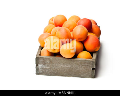 Frische Aprikosen auf Holzkasten isoliert auf weißem Stockfoto