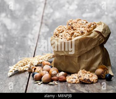 Gesund protein Granola Kekse mit Samen und Nüsse in Papiertüte auf hölzernen Tisch Stockfoto