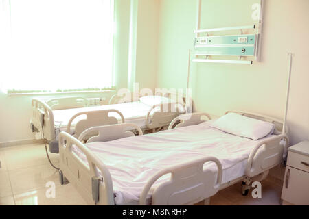 Leere Krankenhaus oder klinischen Zimmer mit bequemen Betten und Fenster mit Sonneneinstrahlung. Stockfoto