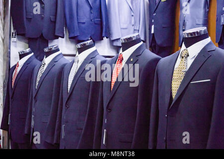Der Mensch passt im klassischen Stil auf Mannequins sind auf dem Display für Verkauf in einem modischen Boutique der modernen Kleidung Stockfoto