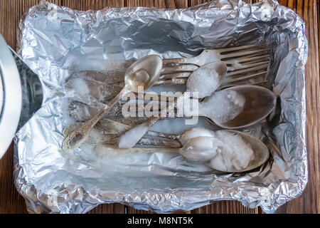 Melchior Löffel und Gabeln in Folie. Zum Reinigen kochendes Wasser gießen Stockfoto