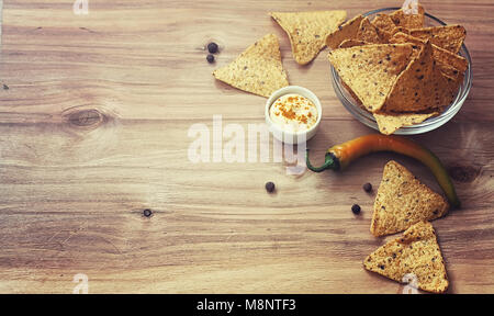 Mais Chips in der jar. Traditionelle Snack für Bier mexikanische Nachos. Nachos mit Gewürzen und Pfeffer auf Holztisch. Stockfoto